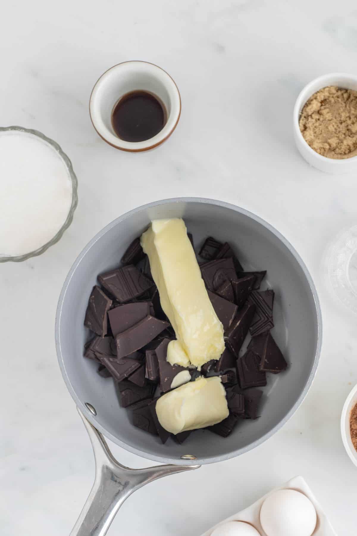 Butter added to dark chocolate in a mixing bowl.