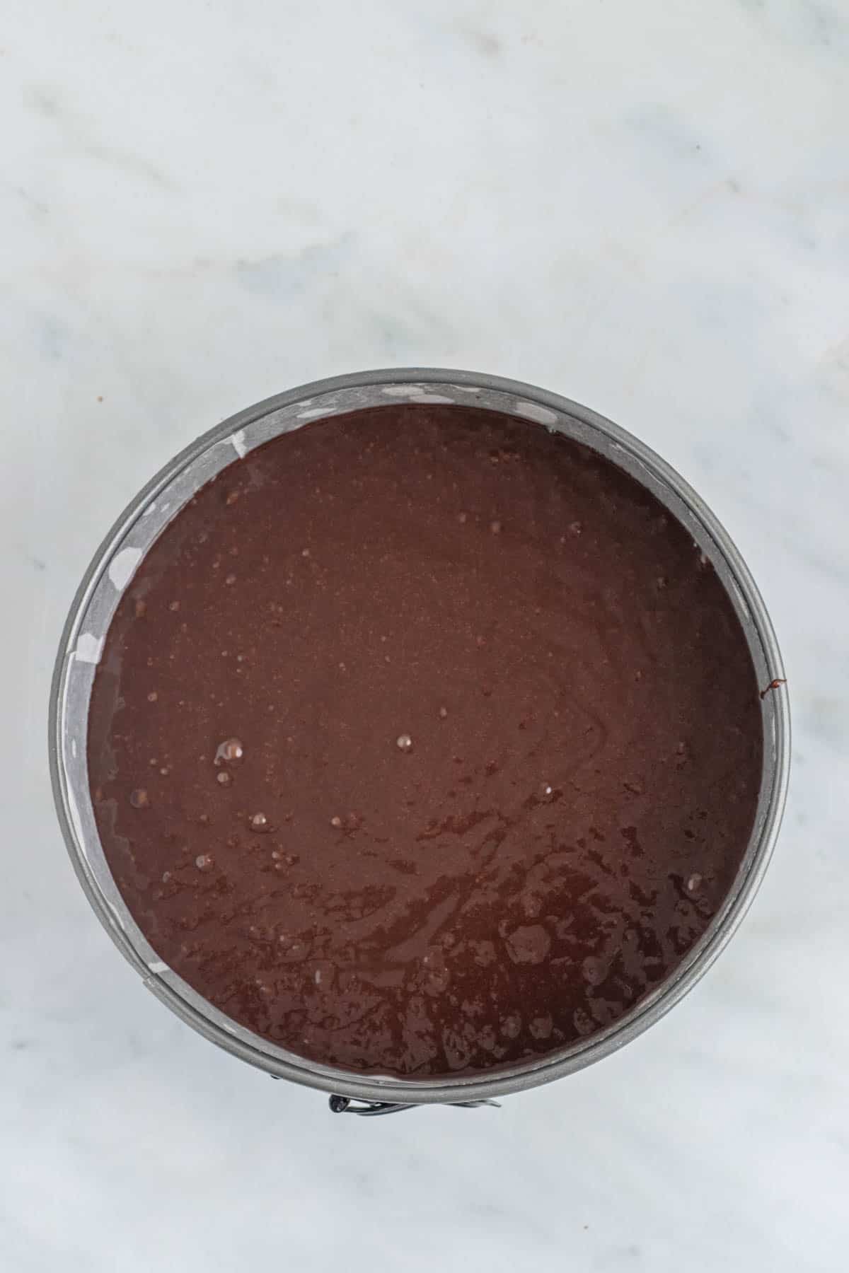 Flourless chocolate torte batter in a round springform cake pan.