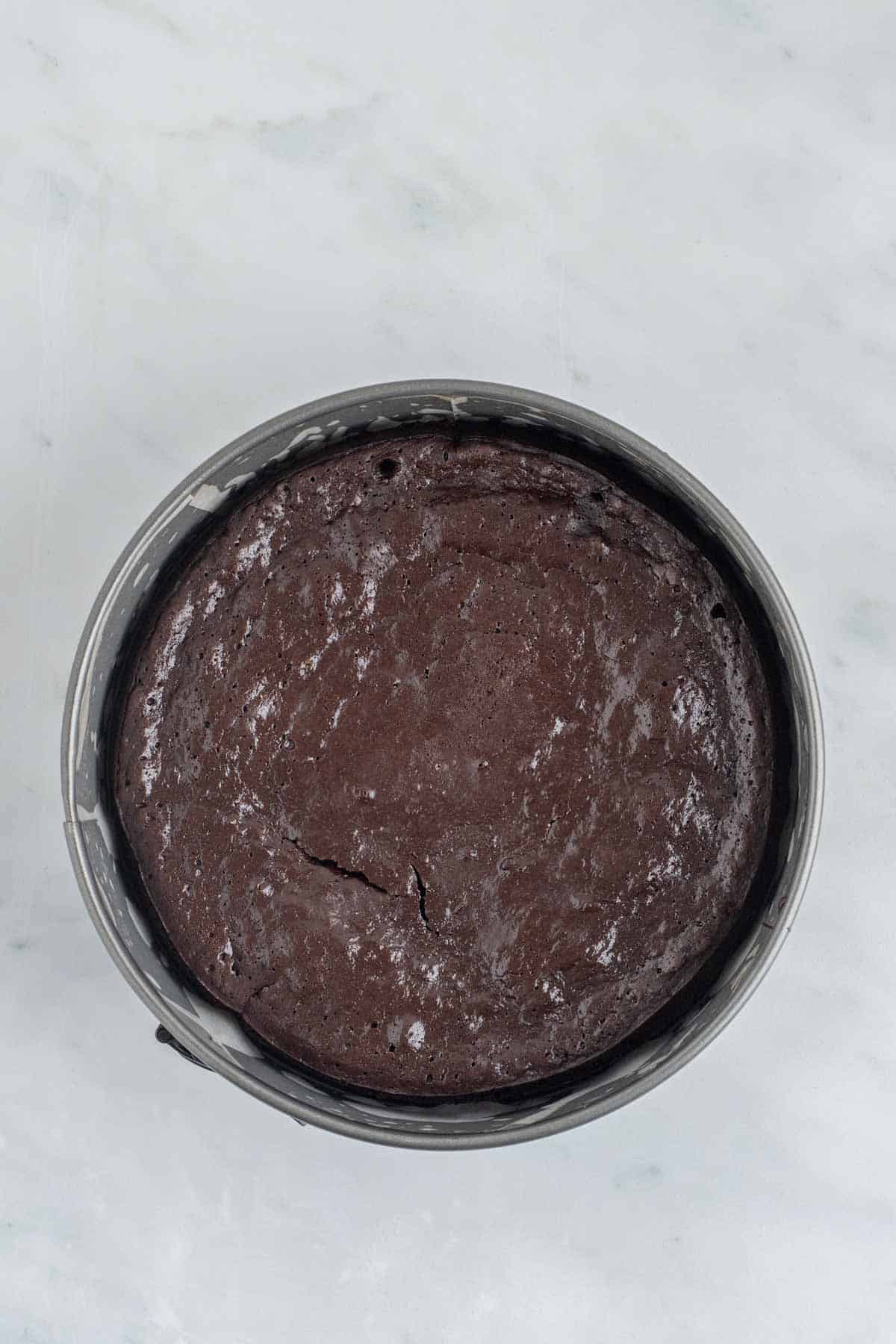Baked chocolate torte inside a round springform pan.