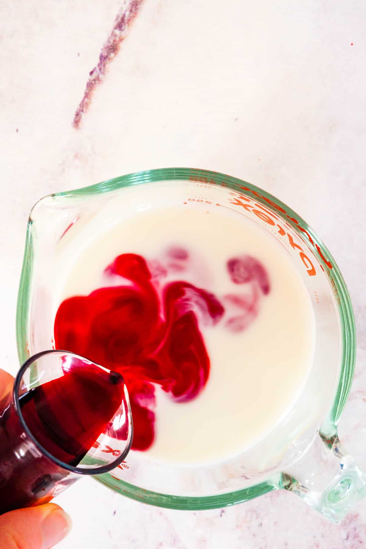 Red food dye added to the cake batter for gluten-free red velvet cake.