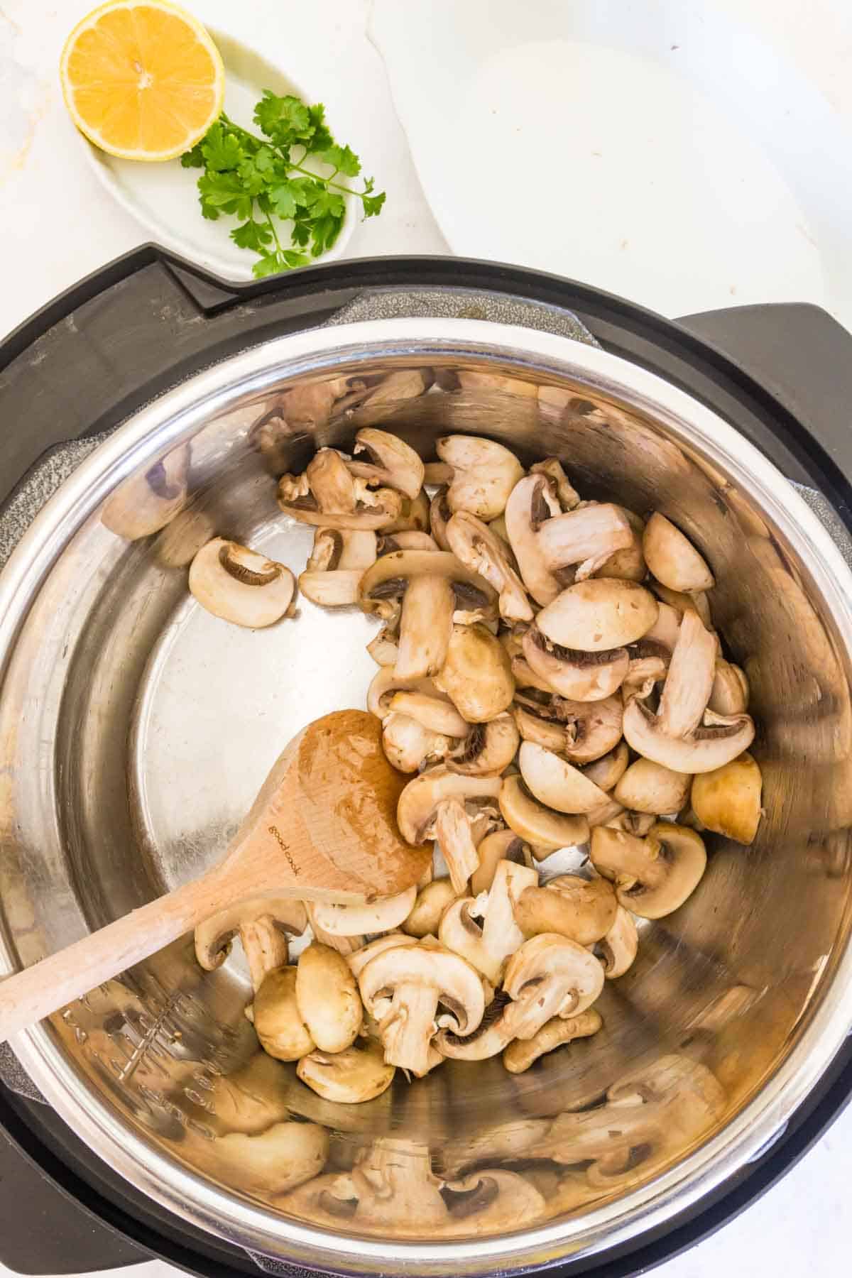 Mushrooms sauteing with butter inside the Instant Pot.