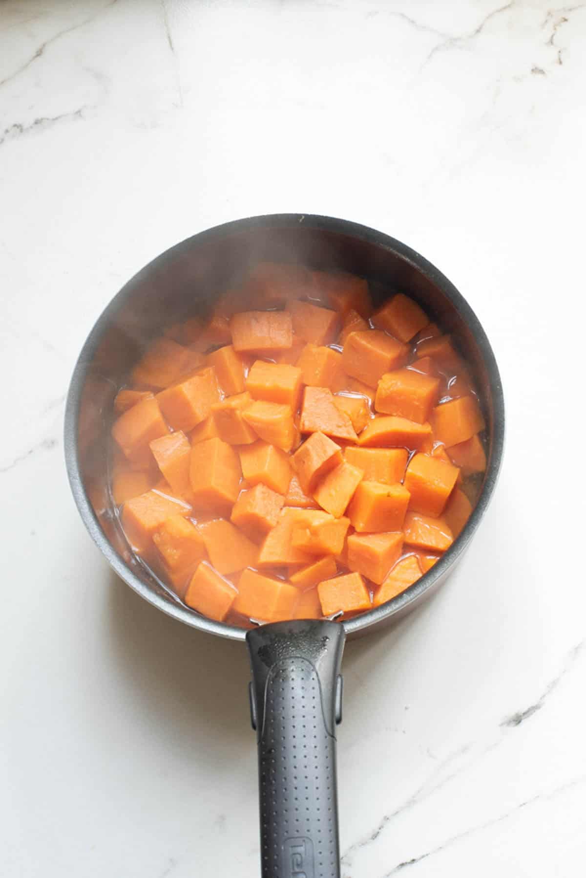 Boiled sweet potatoes in a saucepan.