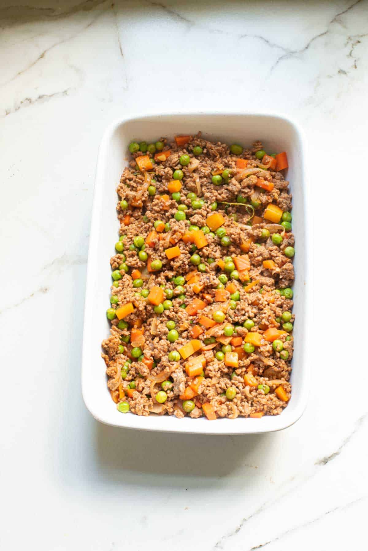 Beef filling spread into the bottom of a 9x13 casserole dish.