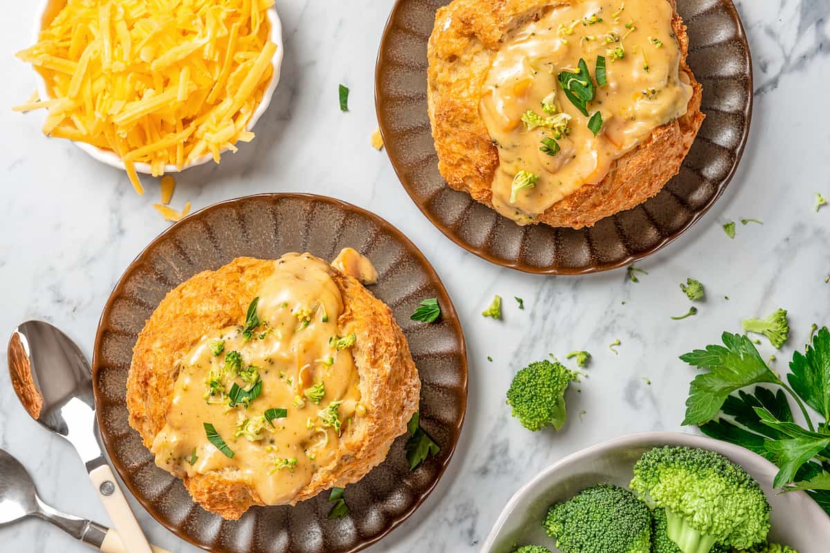 Overhead view of Instant Pot broccoli cheese soup served in two bread bowls.