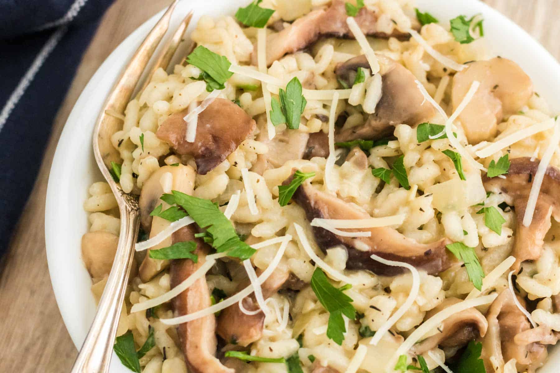 A bowl of mushroom risotto with a spoon.