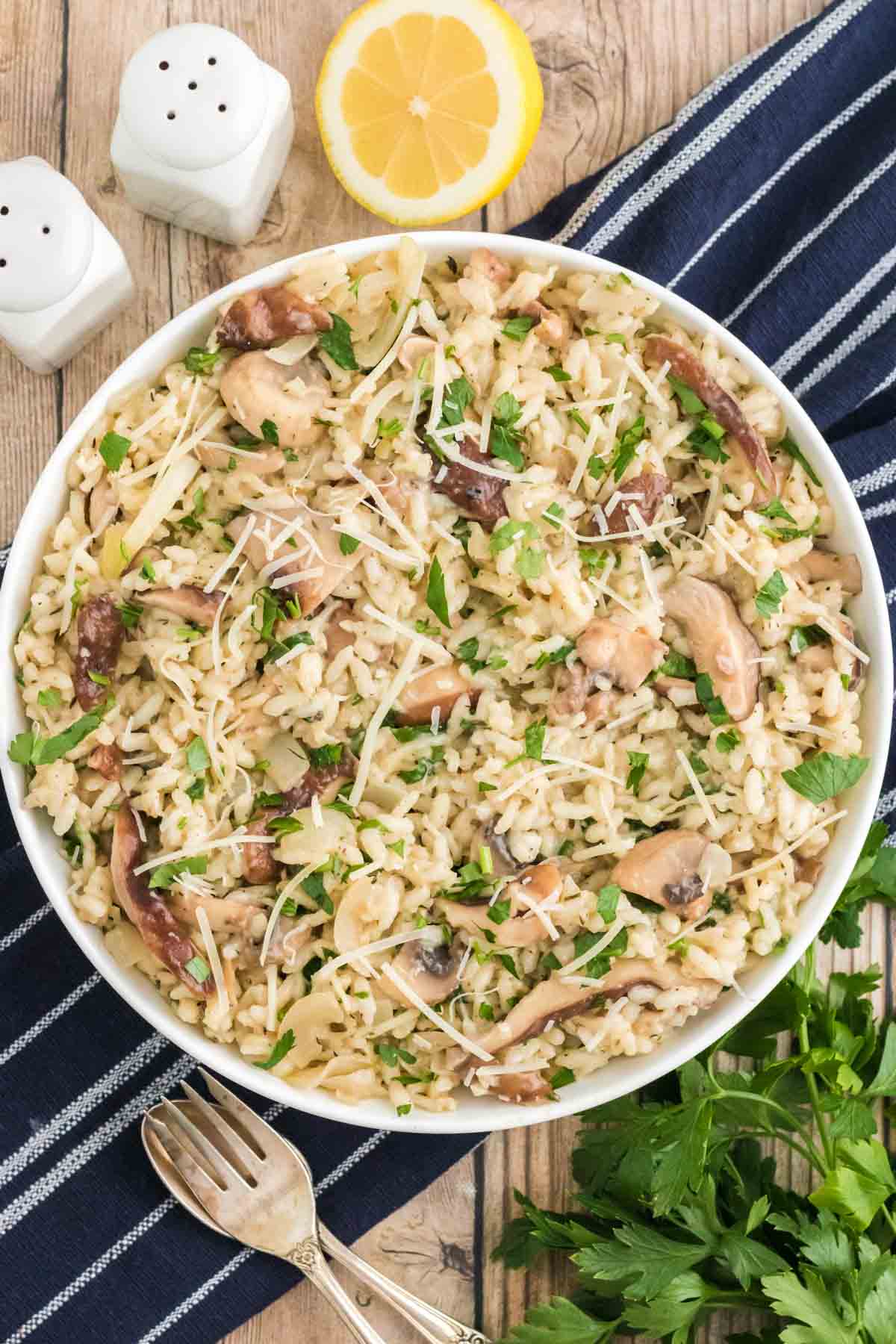 Overhead view of a large bowl of Instant Pot mushroom risotto on a blue table cloth.