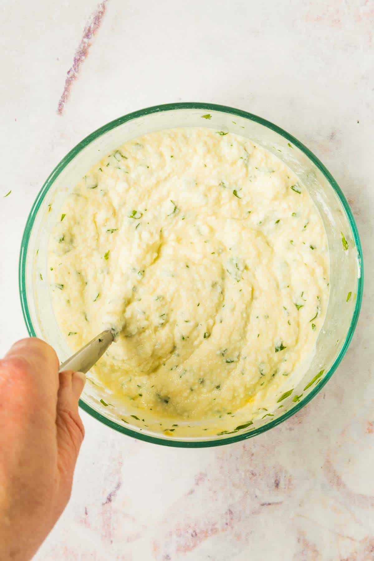 The combined ricotta cheese and egg mixture in a glass bowl.