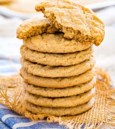 A stack of gluten-free peanut butter cookies with the top cookie broken in half.