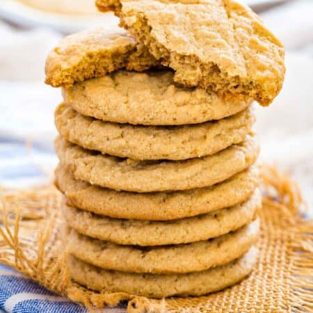 A stack of gluten-free peanut butter cookies with the top cookie broken in half.