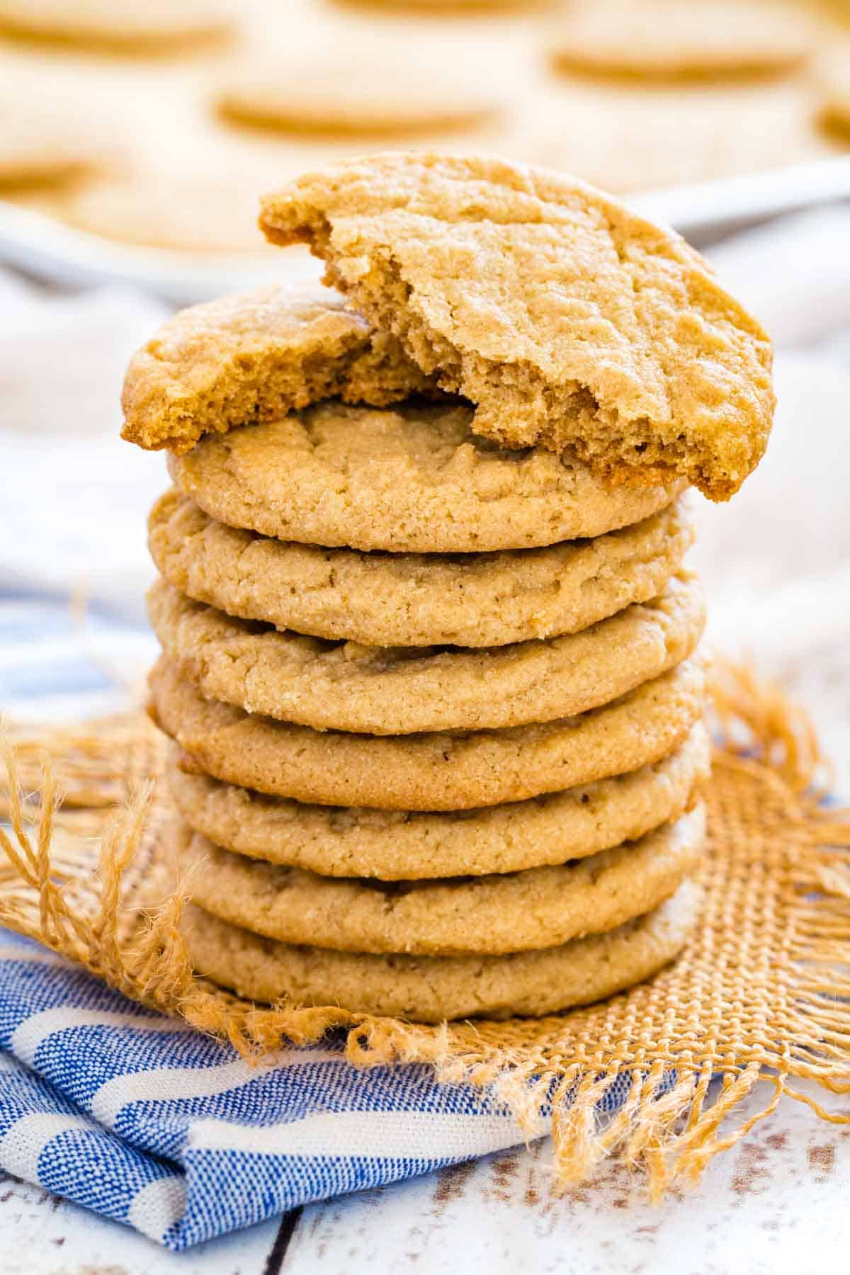 A stack of gluten-free peanut butter cookies with the top cookie broken in half.