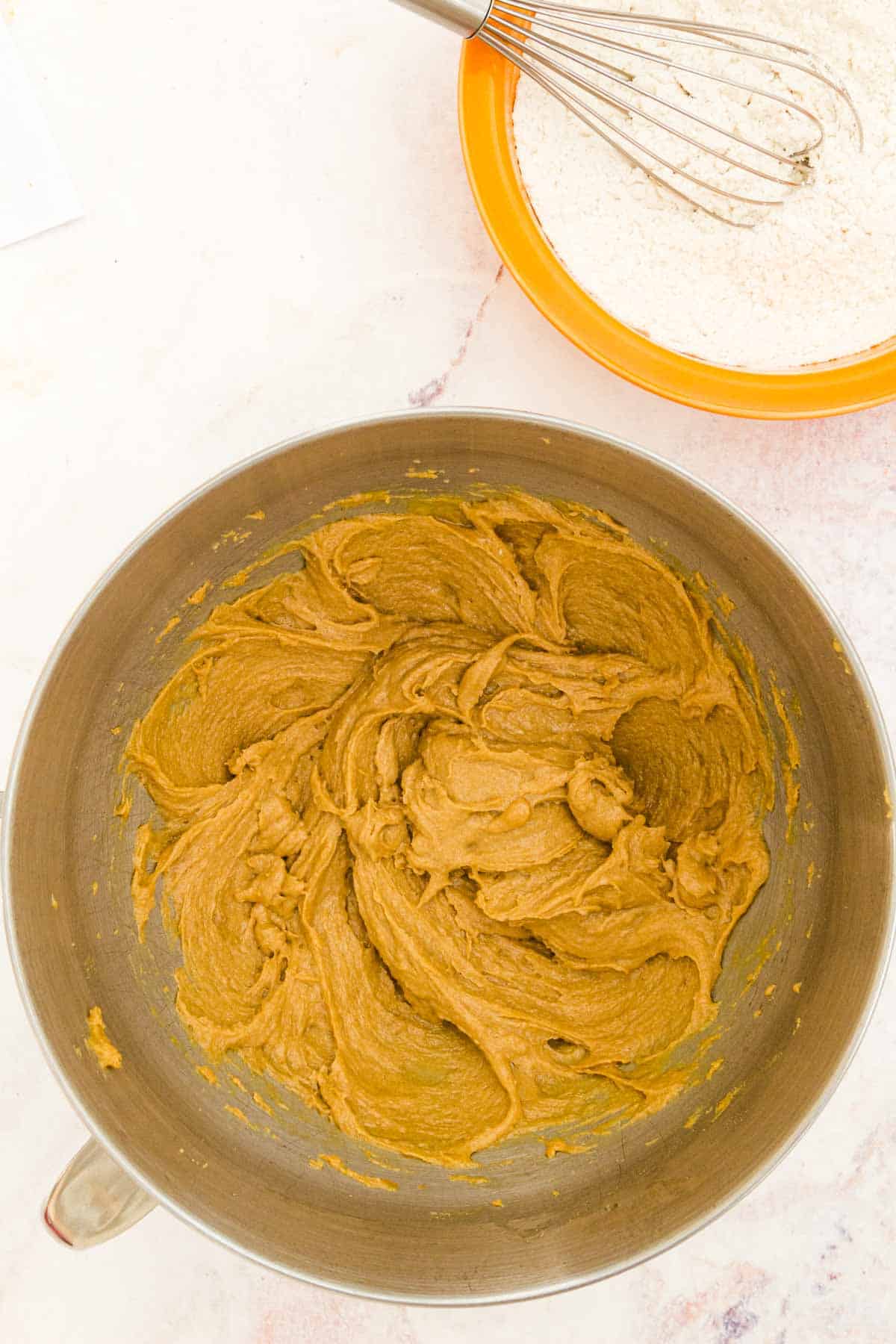 Peanut butter cookie dough in a metal mixing bowl.