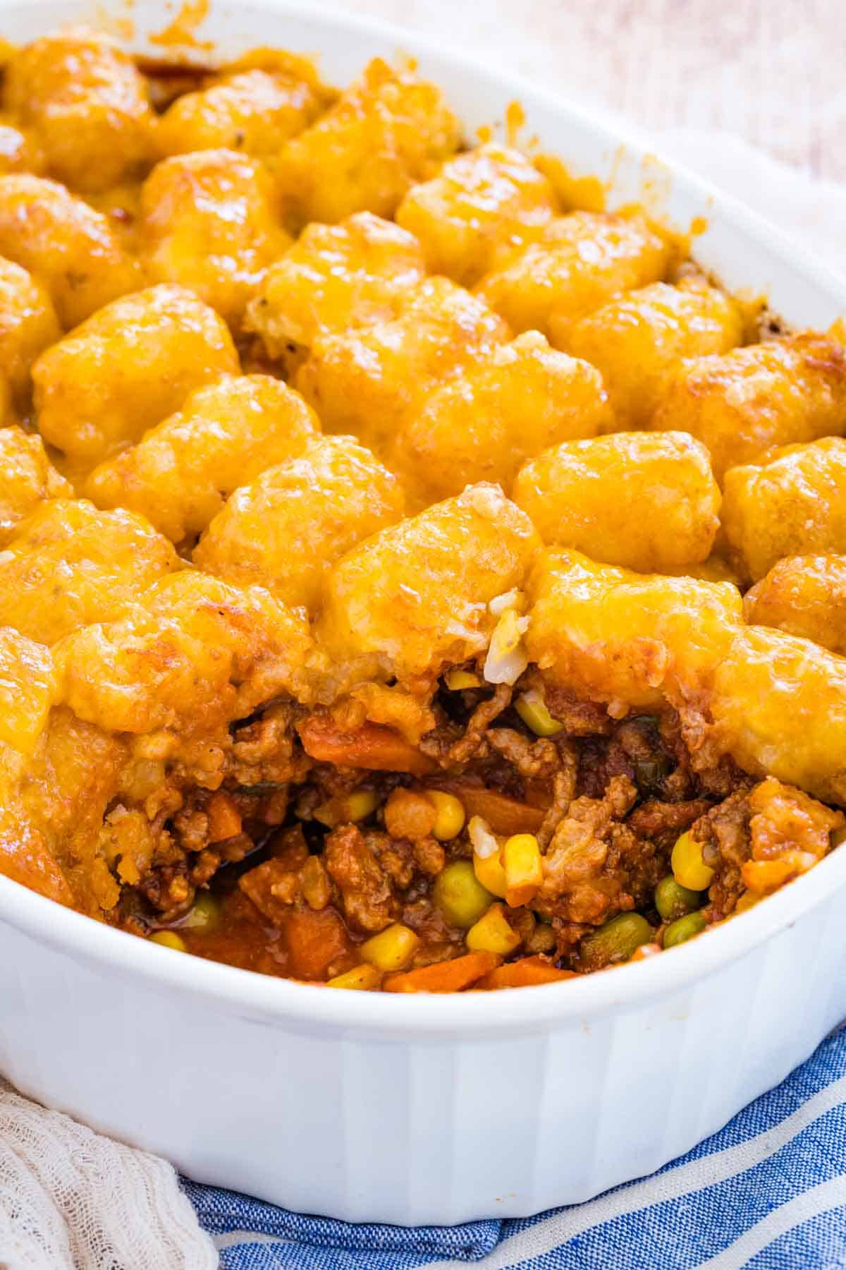Tater tot shepherd's pie casserole in a baking dish with a serving missing.