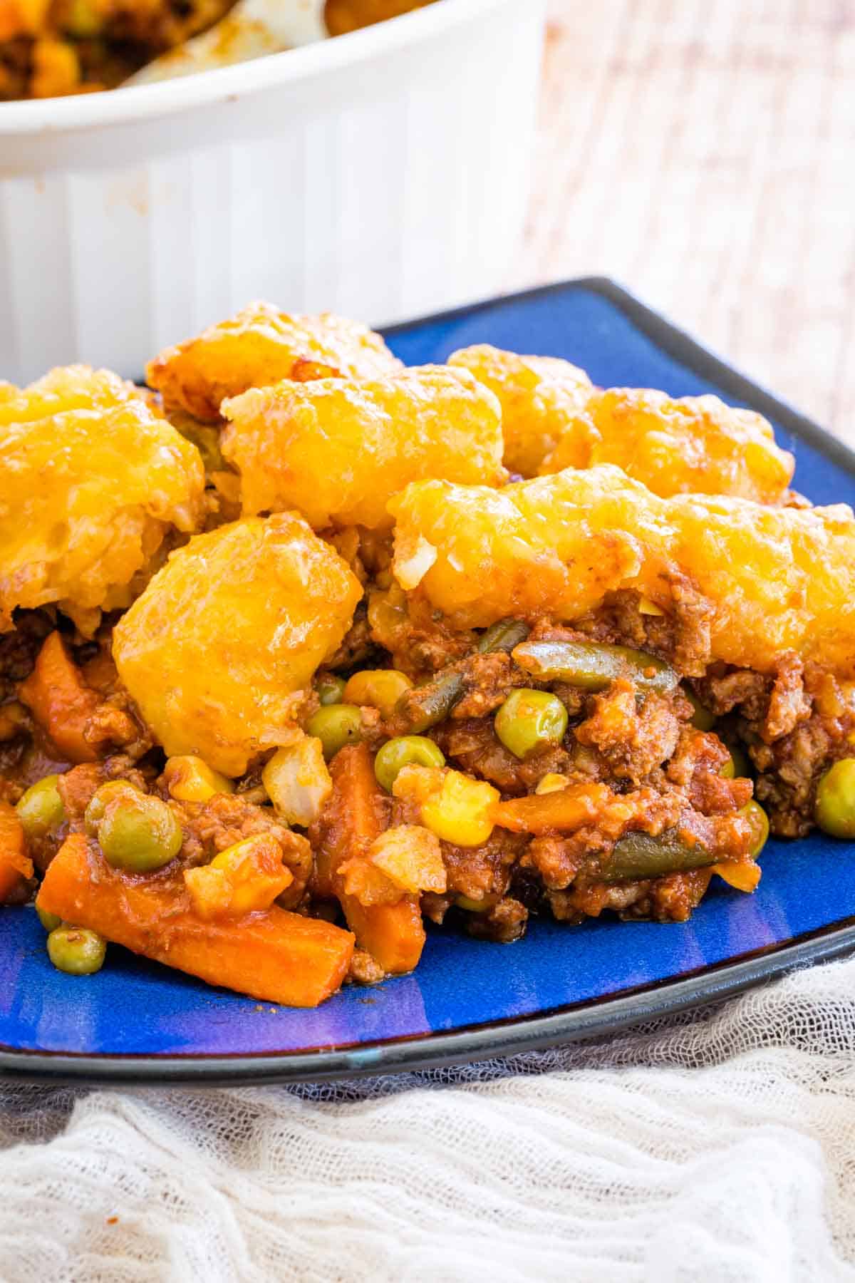 A serving of tater tot shepherd's pie on a blue plate.