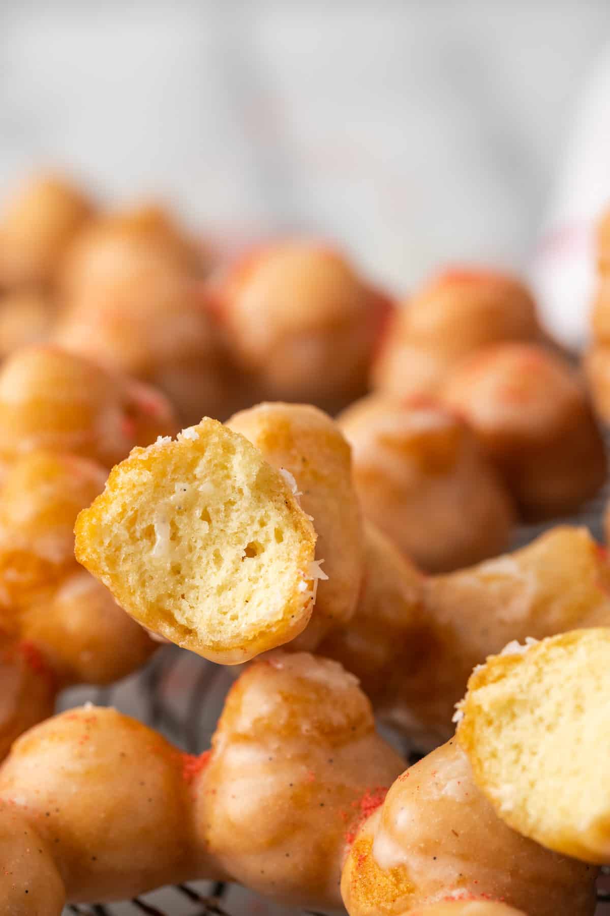 Close up of gluten-free mochi donuts, with a bite missing from one donut.