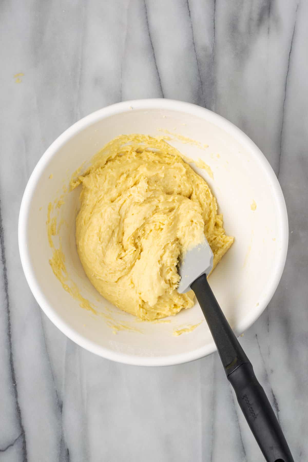 Gluten-free mochi donut batter in a white bowl with a spatula.