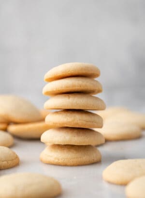 A stack of gluten-free vanilla wafers on a countertop, surrounded by more wafers.