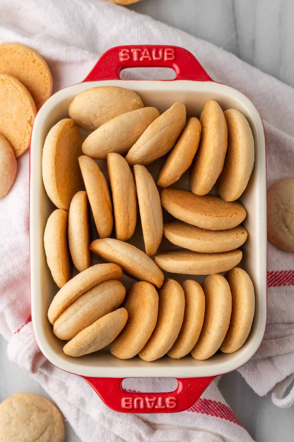 Assorted gluten-free vanilla wafers arranged inside a rectangular baking dish.