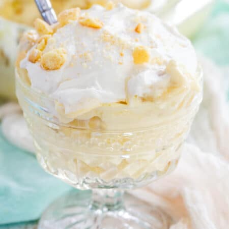 Gluten-free banana pudding served in a coup glass, with a spoon dipped into the top.