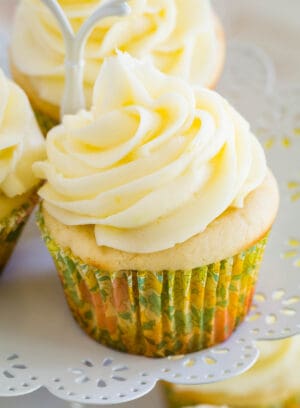 A frosted gluten-free lemon cupcake on a cupcake stand.