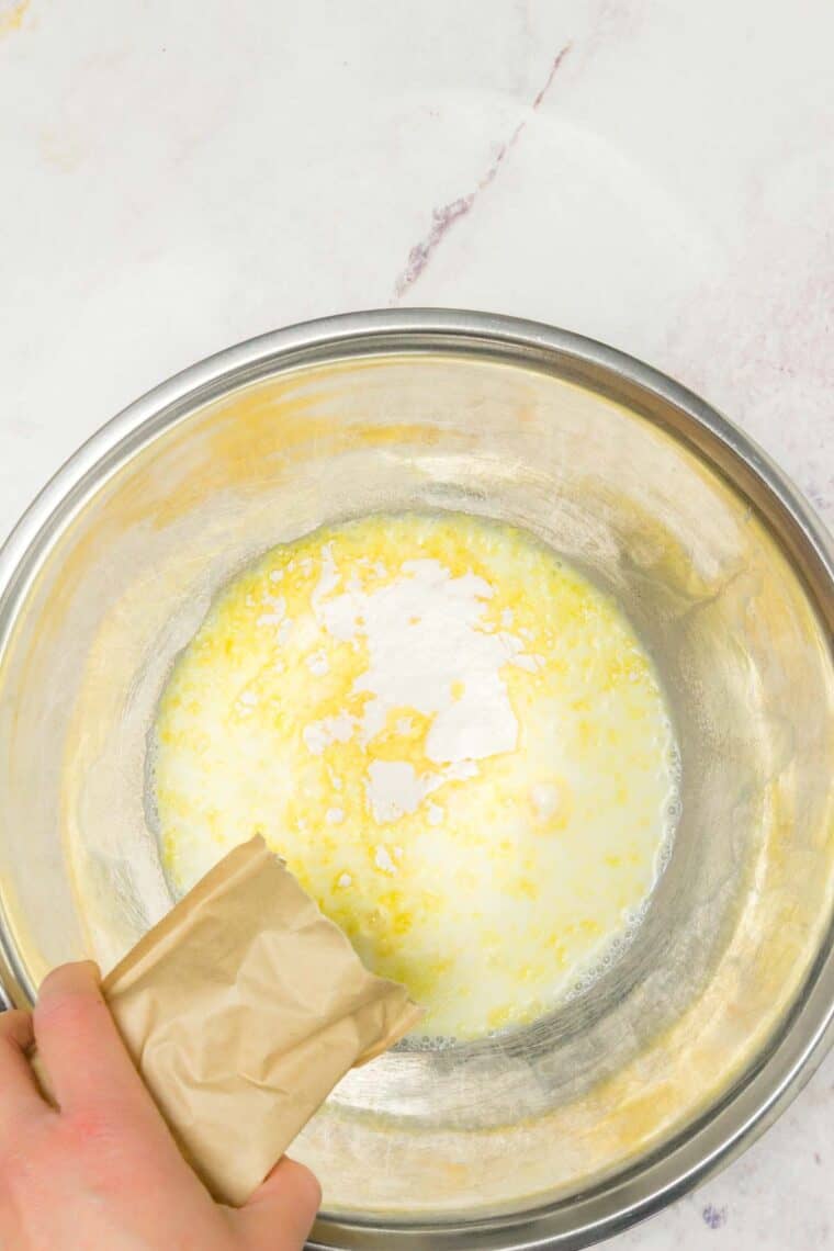 Instant pudding mix is added to a bowl with milk.