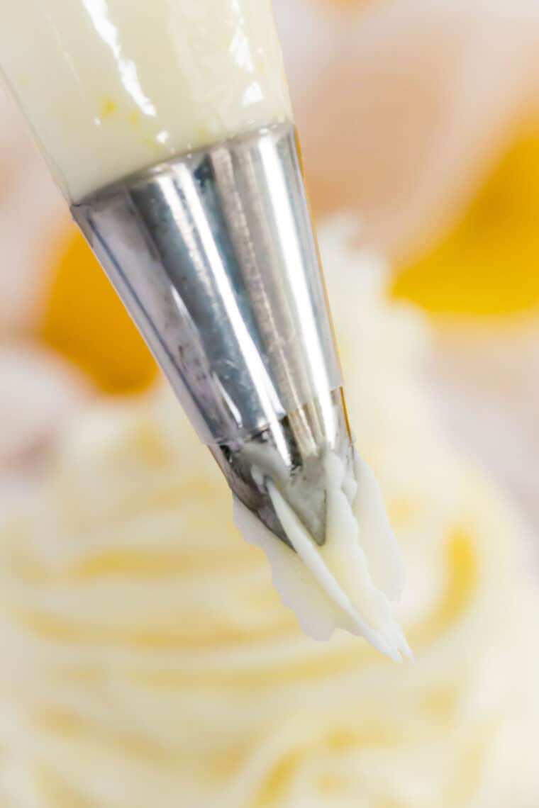 Close up of lemon buttercream frosting pressed out from a piping tip.