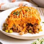 A serving of shepherd's pie on a white plate with text overlay that says "Sweet Potato Shepherd's Pie".