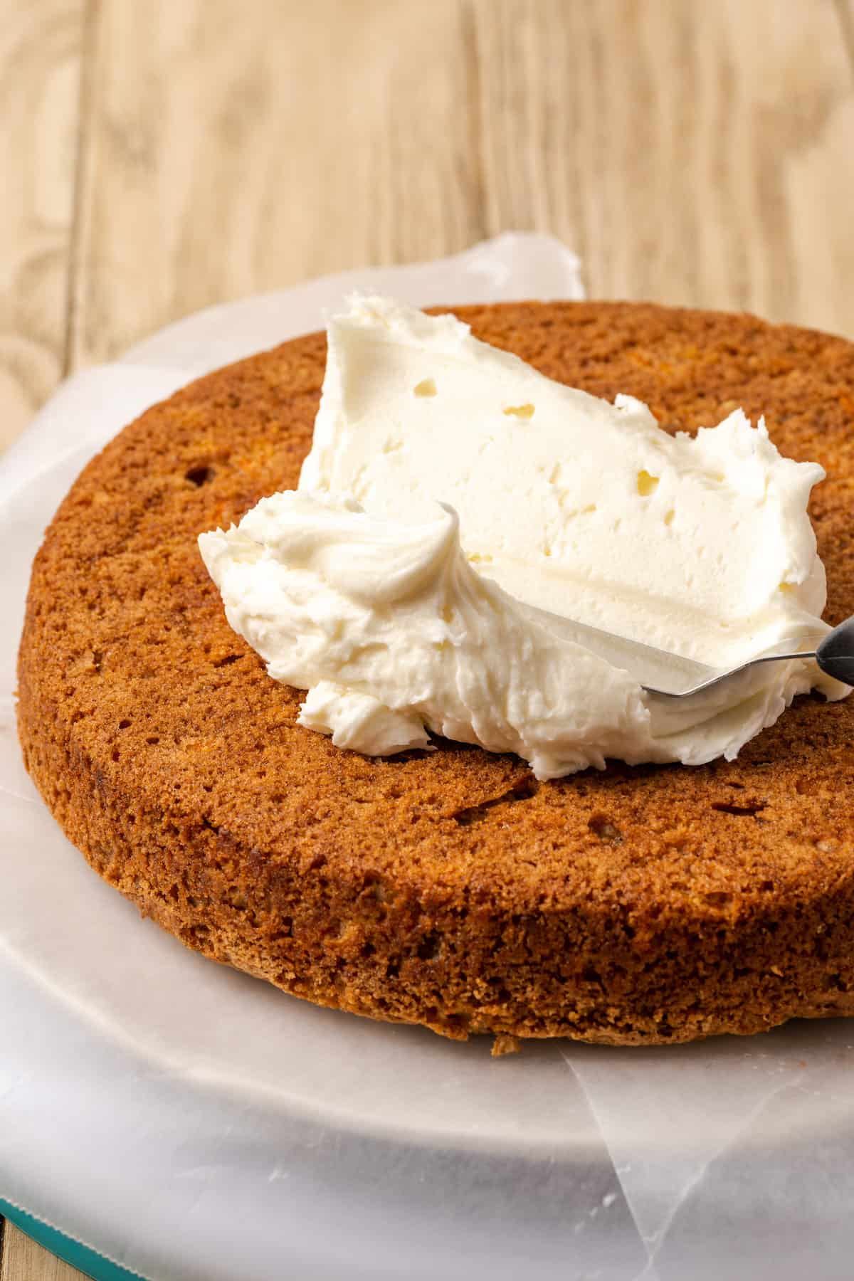 A dollop of cream cheese frosting on top of a single layer of gluten-free carrot cake.