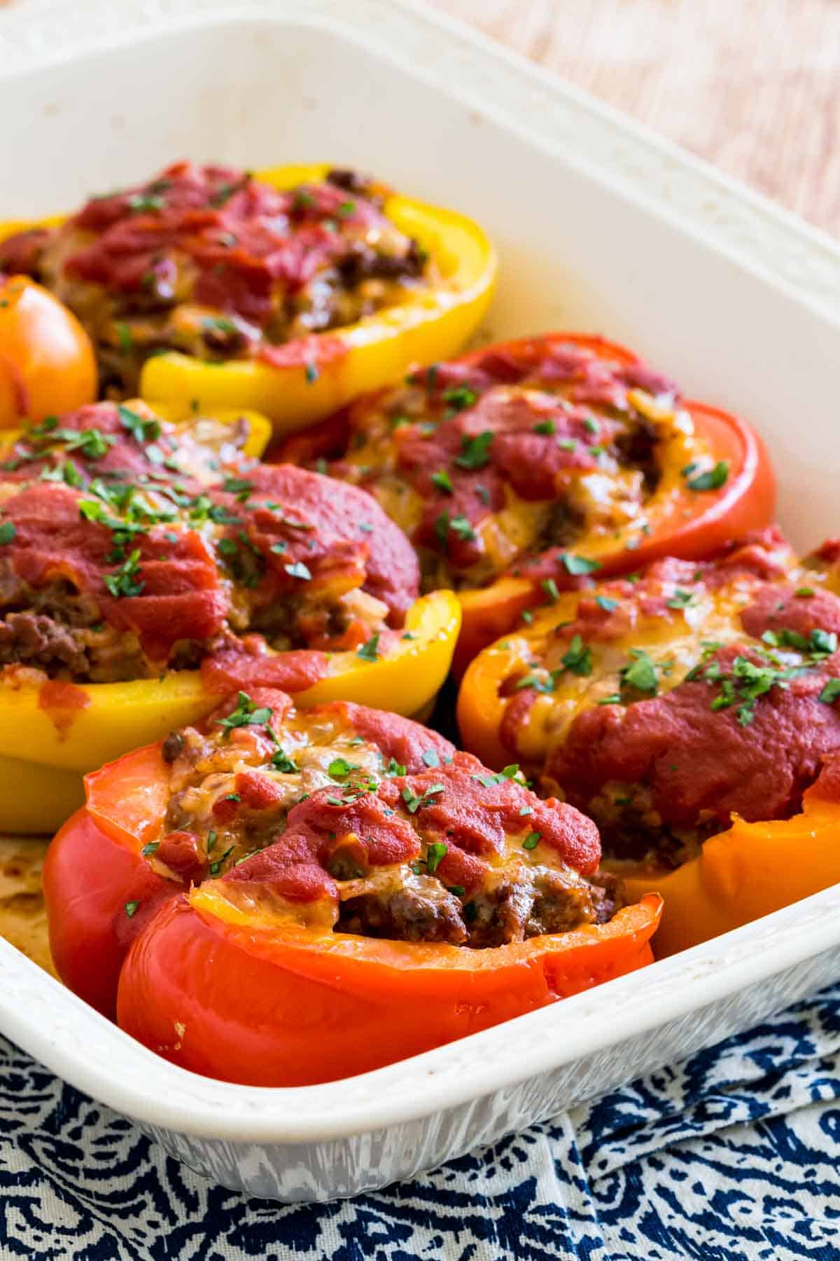 Stuffed peppers in a white ceramic baking dish.