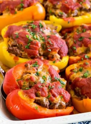 Stuffed peppers in a white ceramic baking dish.