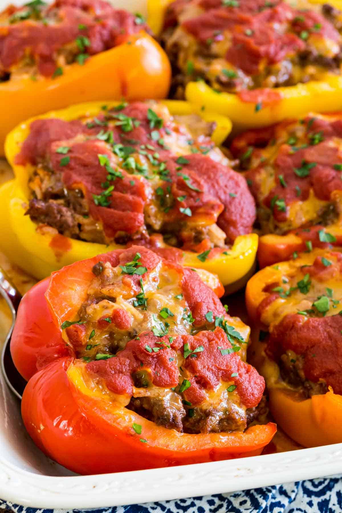 Stuffed peppers in a white ceramic baking dish.