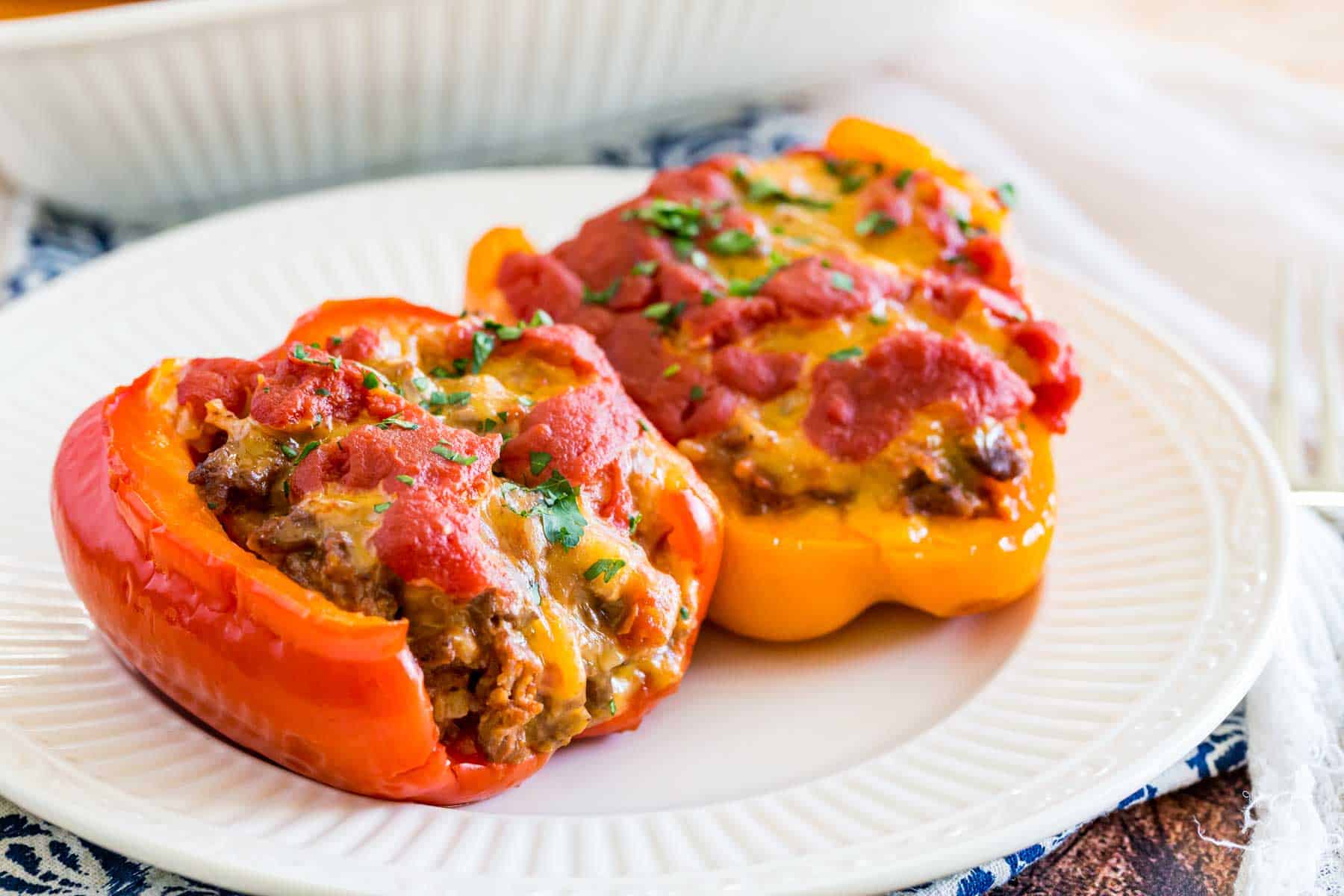 Two stuffed pepper halves on a white plate.