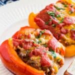 Two stuffed pepper halves on a white plate.