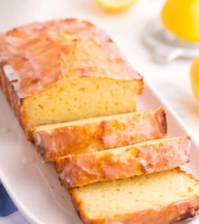 A sliced gluten free lemon pound cake on a white oval platter.