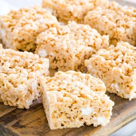 Gluten-free rice krispies treats on a wooden platter.