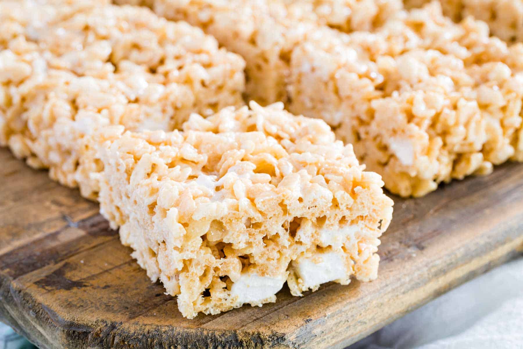 Gluten-free rice krispies treats on a wooden platter.