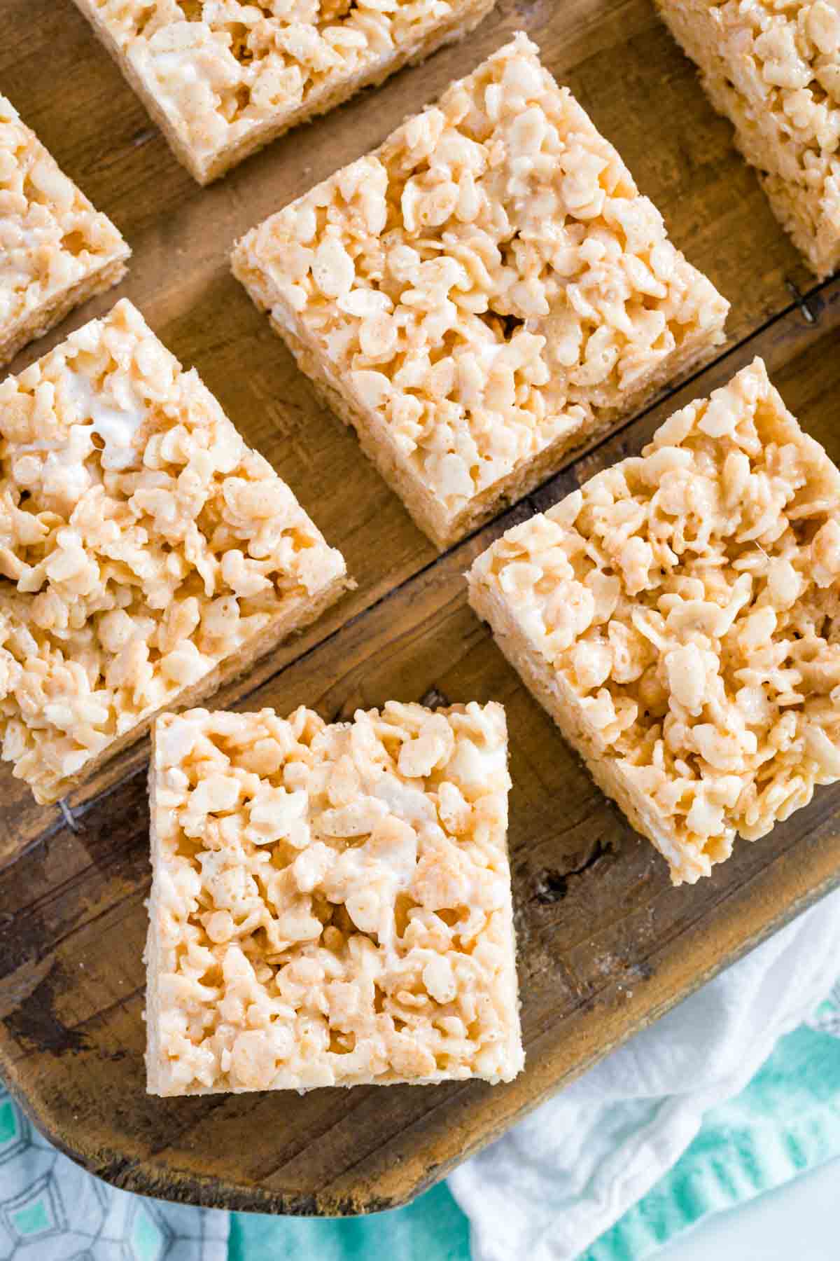 Overhead view of assorted gluten-free rice krispies treats on a wooden platter.