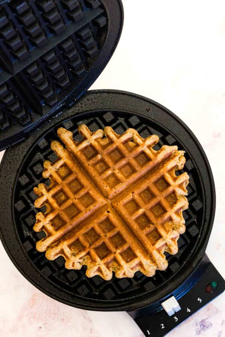A cooked waffle in a waffle iron.