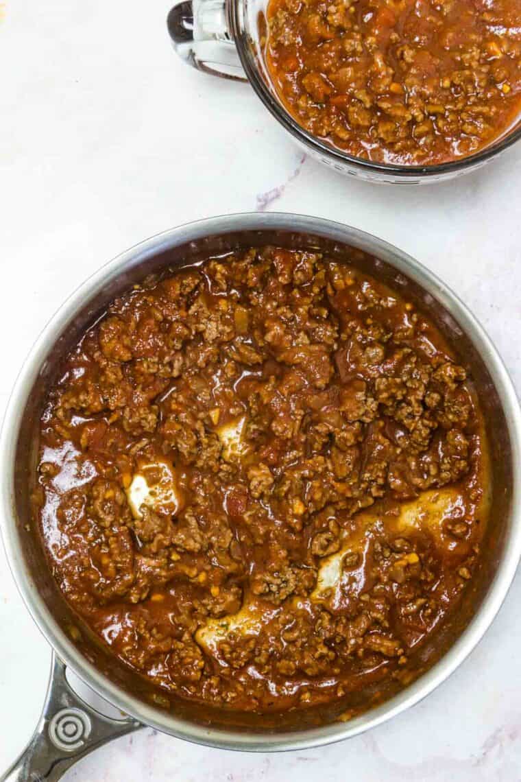 A layer of meat sauce in the bottom of a skillet.