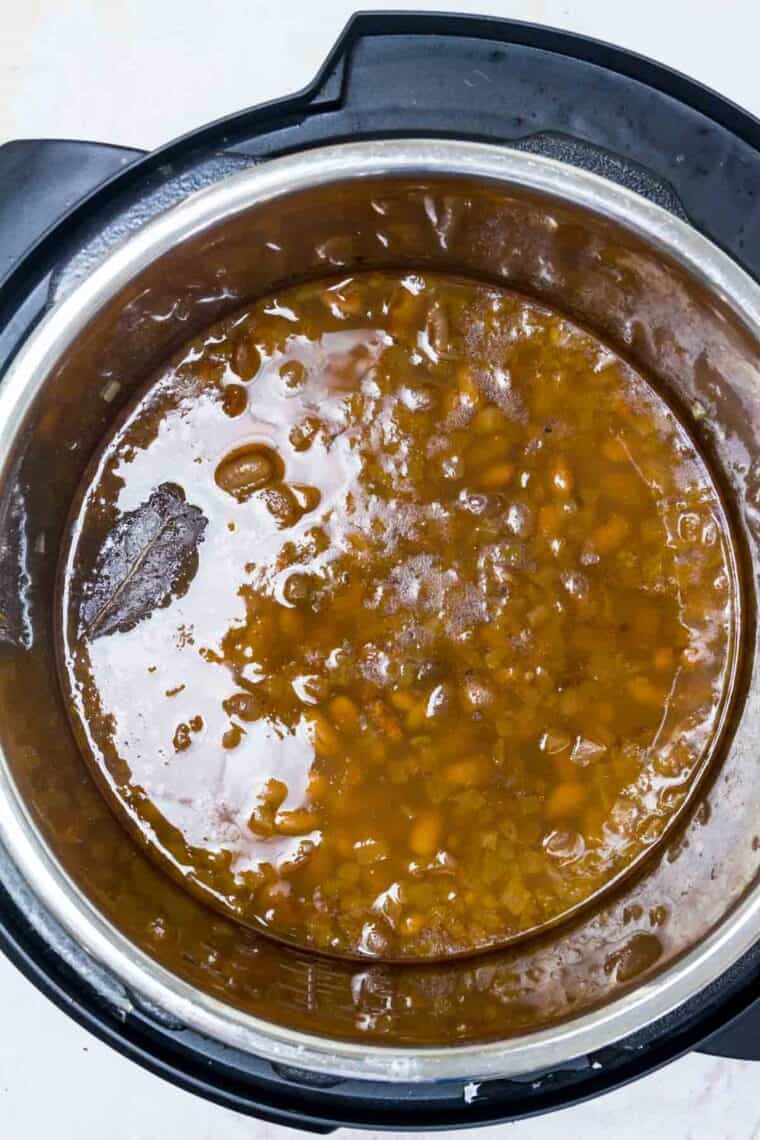 Cooked pinto beans in broth inside the instant pot.