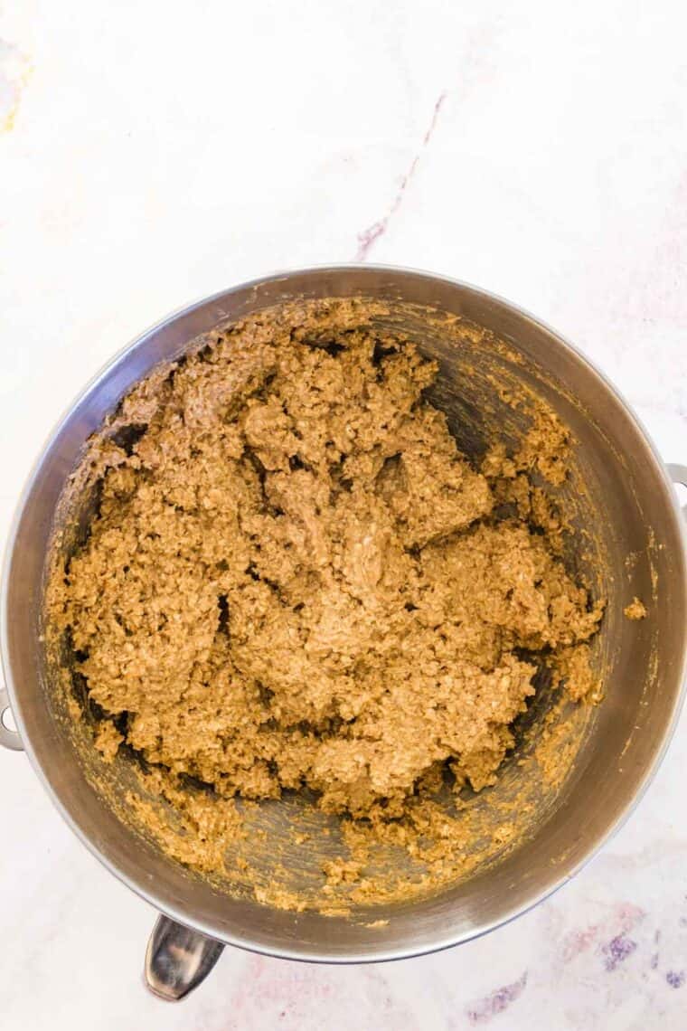 Oatmeal cookie dough in a metal mixing bowl.