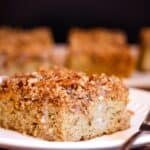 A piece of cake on a plate with text overlay that says "Almond Flour Pumpkin Crumb Cake".