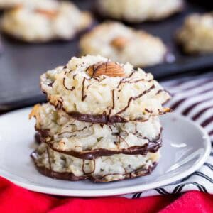 Three almond joy cookies stacked on a white plate.