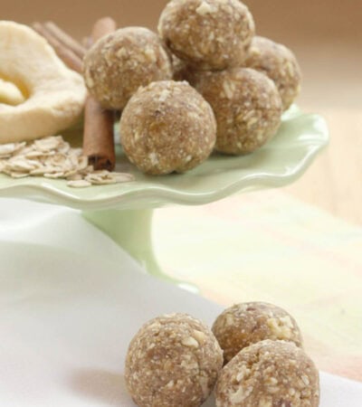Three apple cinnamon bites on a napkin with more on a stand in the background.