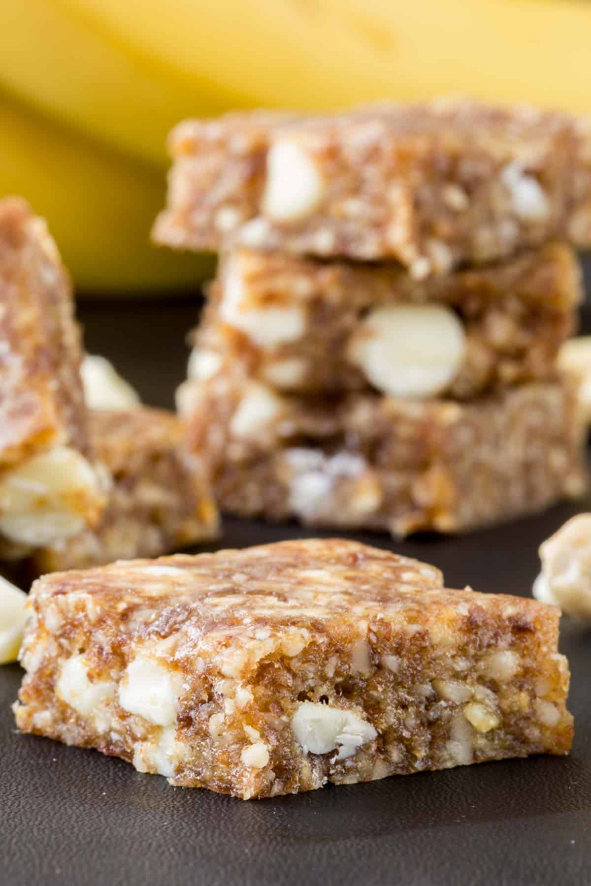 A no-bake banana snack bar in the foreground with a stack of bars in the background.