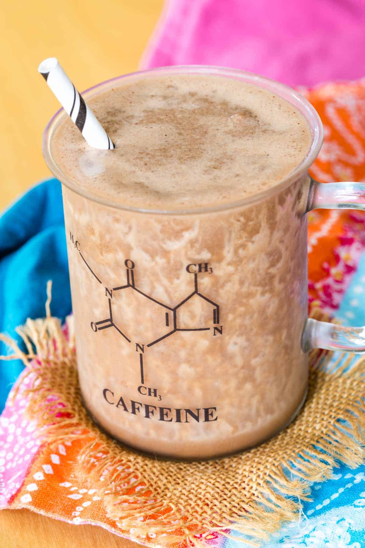 Chocolate Almond Protein Blended Cold Brew in a glass with the caffeine molecule on it