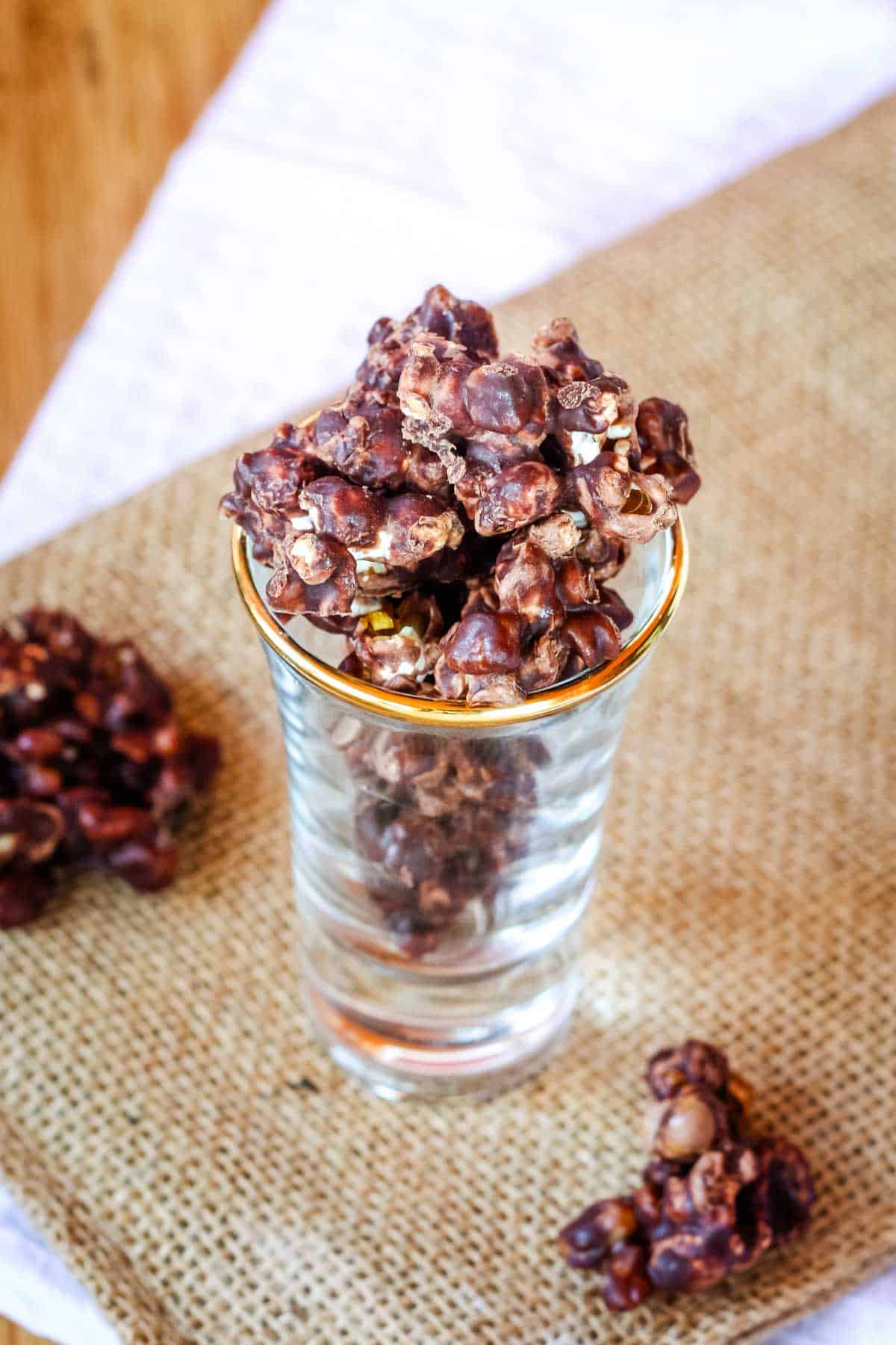 A shot glass filled with Chocolate-covered Popcorn.