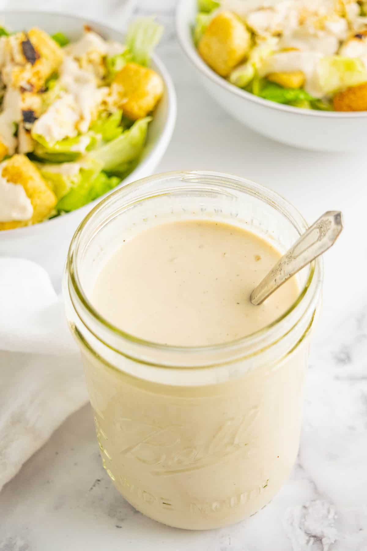A mason jar of Greek yogurt Caesar salad dressing.