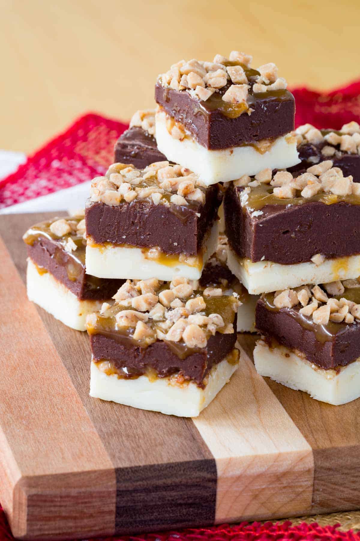 A pyramid of Fudge pieces with caramel and toffee on a wooden board.