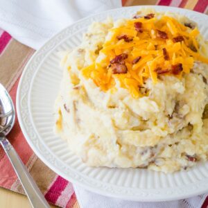 A bowl of cheesy mashed potatoes with bacon.