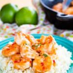 A closeup of Chili Lime Shrimp coated in a glaze on top of a bed of cauliflower rice.